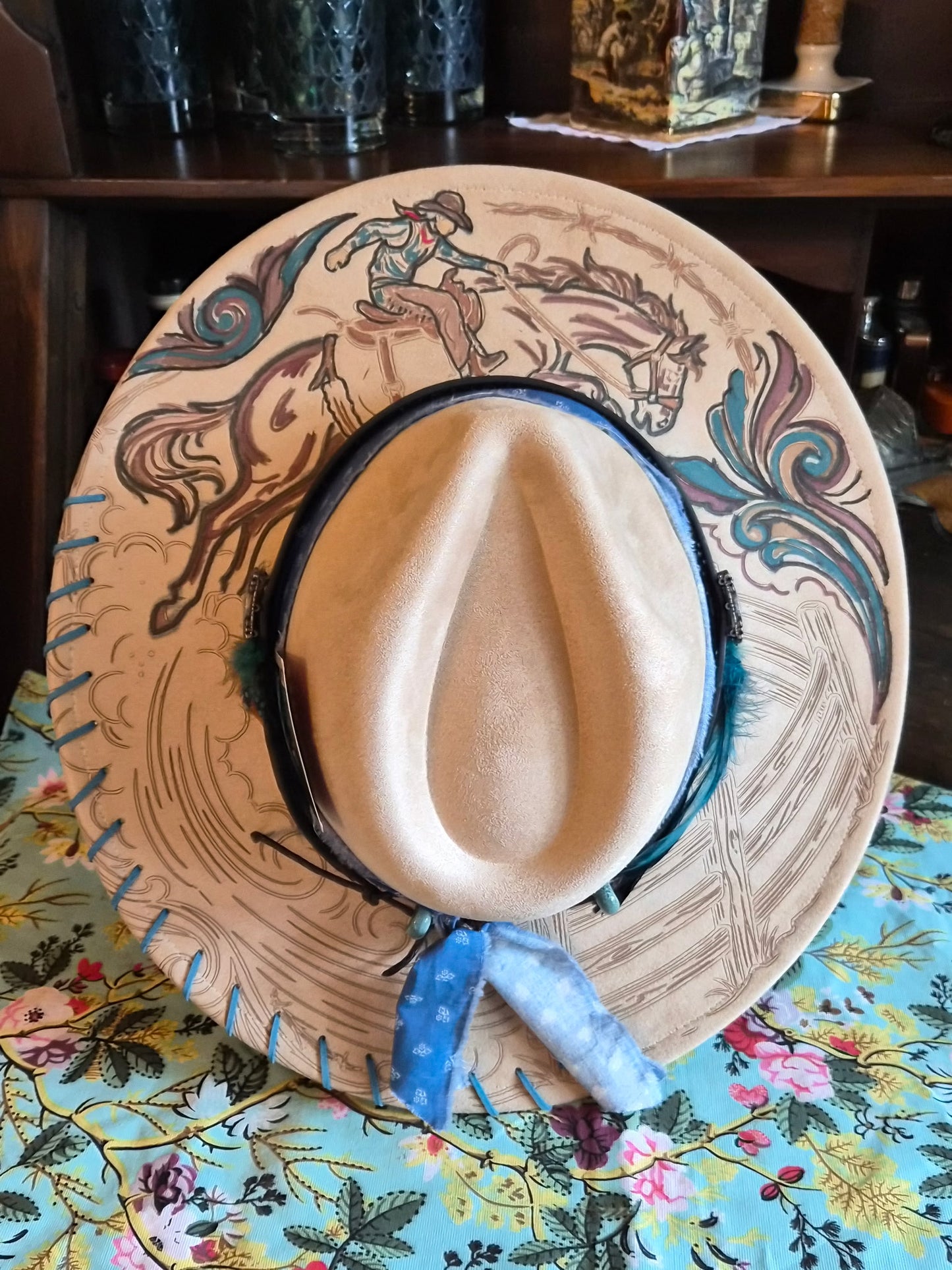 Faux suede wide brim rancher with hand-painted rodeo cowboy laser design, top view showing full brim artwork