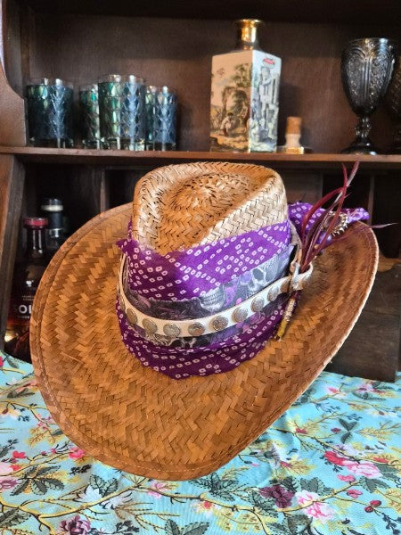 Natural straw cowboy hat with exclusive Purlicue Pinch purple bandana and skull concho hatband